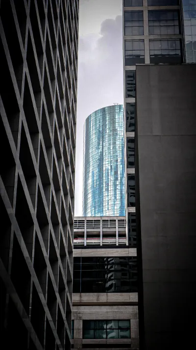 Black-and-white downtown towers with a blue glass cylinder
